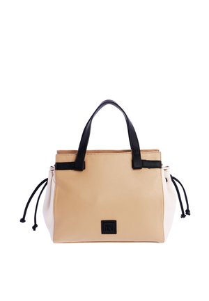 Bolso de mano beige y blanco con asas negras y laterales con cordones, forma rectangular y un logo negro cuadrado en el centro delantero.