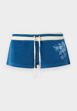 Modré froté šortky s bielymi pásikmi na páse, sťahovacou šnúrkou a svetlomodrou kvetinovou potlačou na pravej strane.