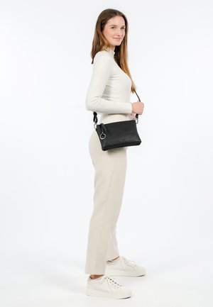 Black textured leather crossbody bag with a zippered pocket, adjustable strap, and silver-tone hardware; compact rectangular shape.