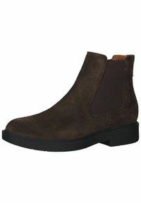 Stivale alla caviglia in suede marrone con pannelli elastici sui lati e suola in gomma nera. Presenta una punta arrotondata e dettagli di cucitura minimi.