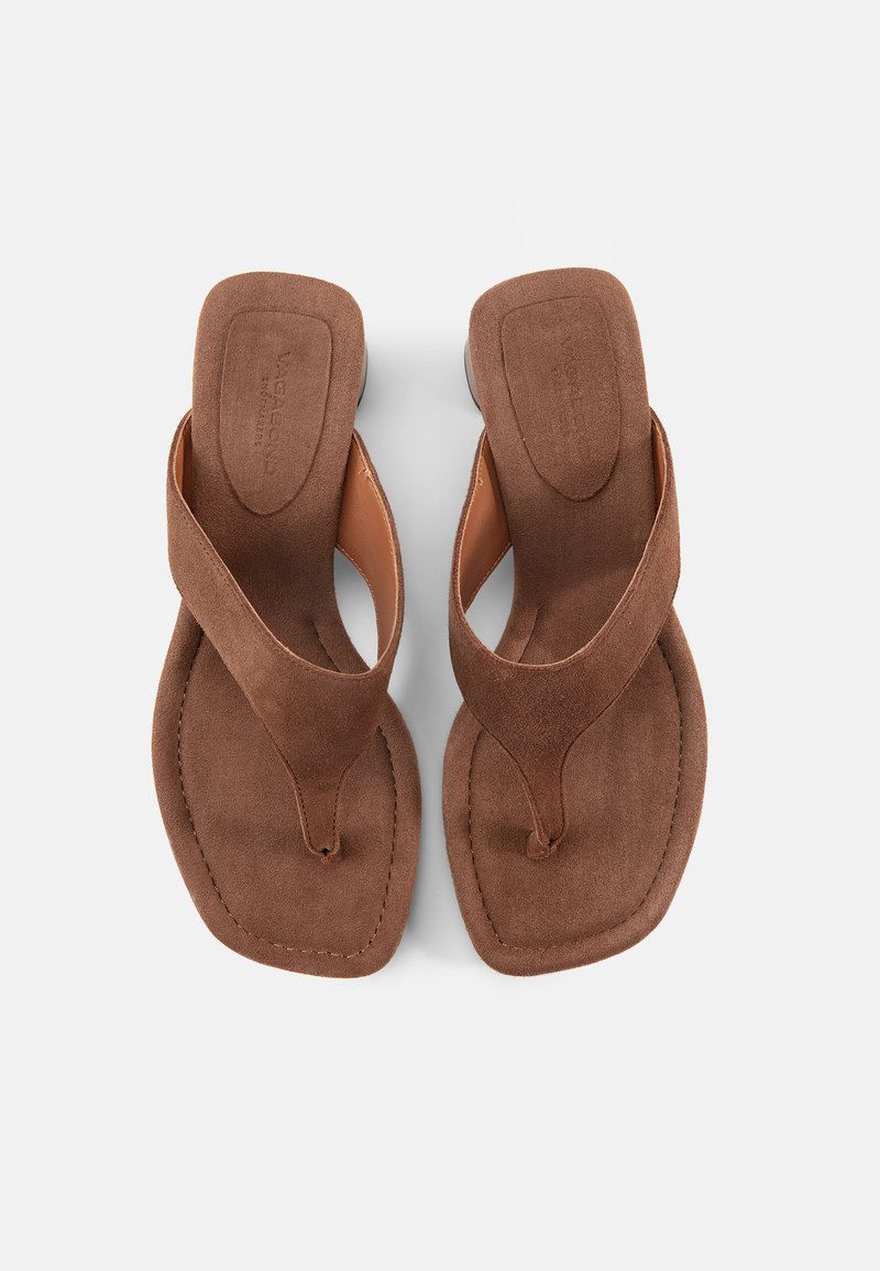 Bruine suède teenslippers met vierkante neuzen en brede bandjes, gezien van bovenaf op een witte achtergrond.