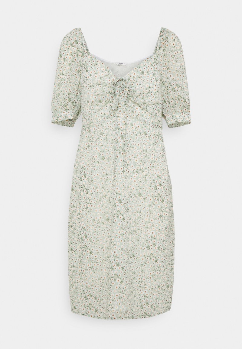 Robe vert clair longueur genou avec petit imprimé floral blanc, manches courtes bouffantes, encolure carrée et détail noué à l’avant.
