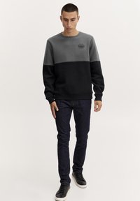 Ronde hals sweatshirt met een kleurblokontwerp in grijs en zwart. Gemaakt van een katoenmix, met ribgebreide manchetten en een klein logo op de borst.