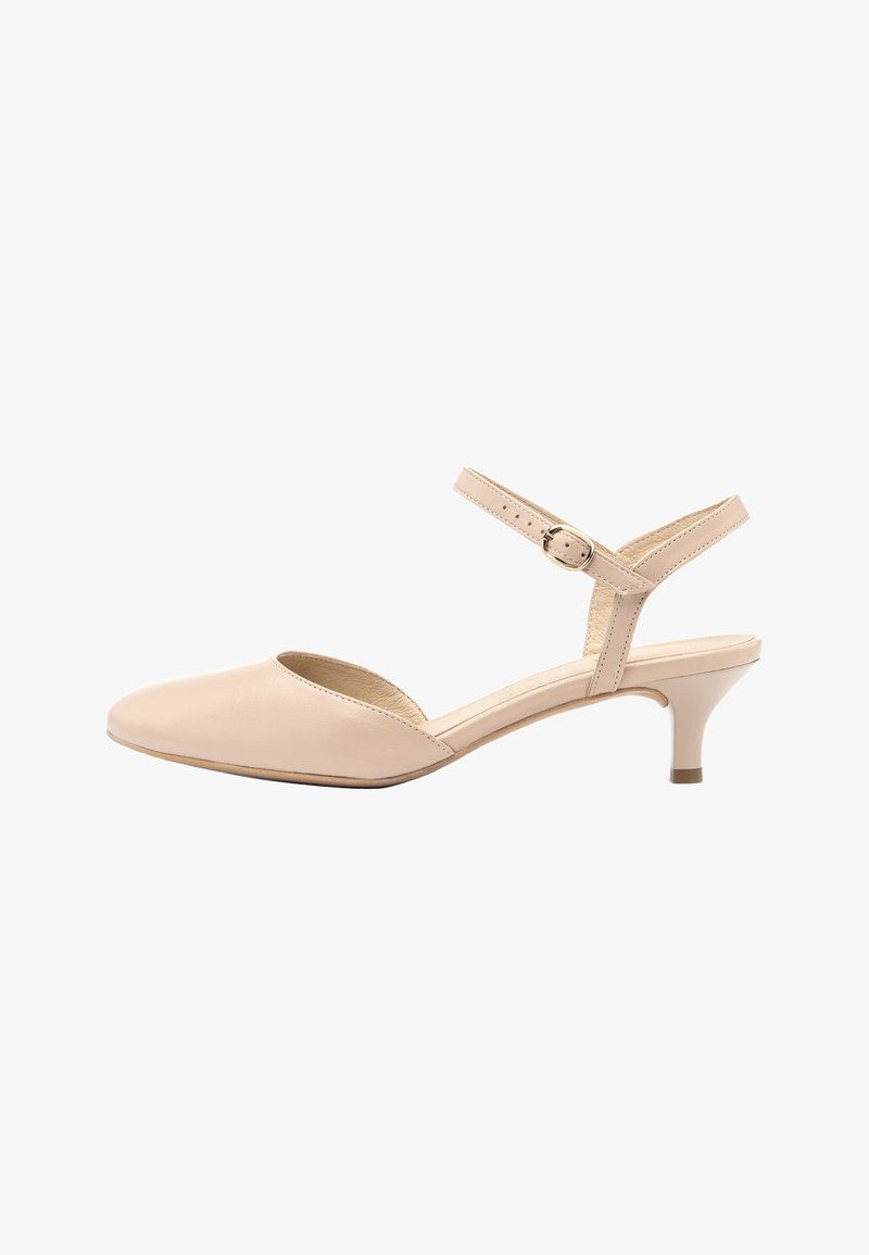 Chaussure beige pour femme à talon bas, bout pointu, bride à la cheville et boucle dorée, vue de côté sur fond blanc.