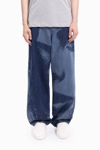 Široke jeans hlače prikazujejo gradient temno in svetlo modrih odtenkov, značilne po teksturiranem, pegastem vzorcu in sproščenem kroju.
