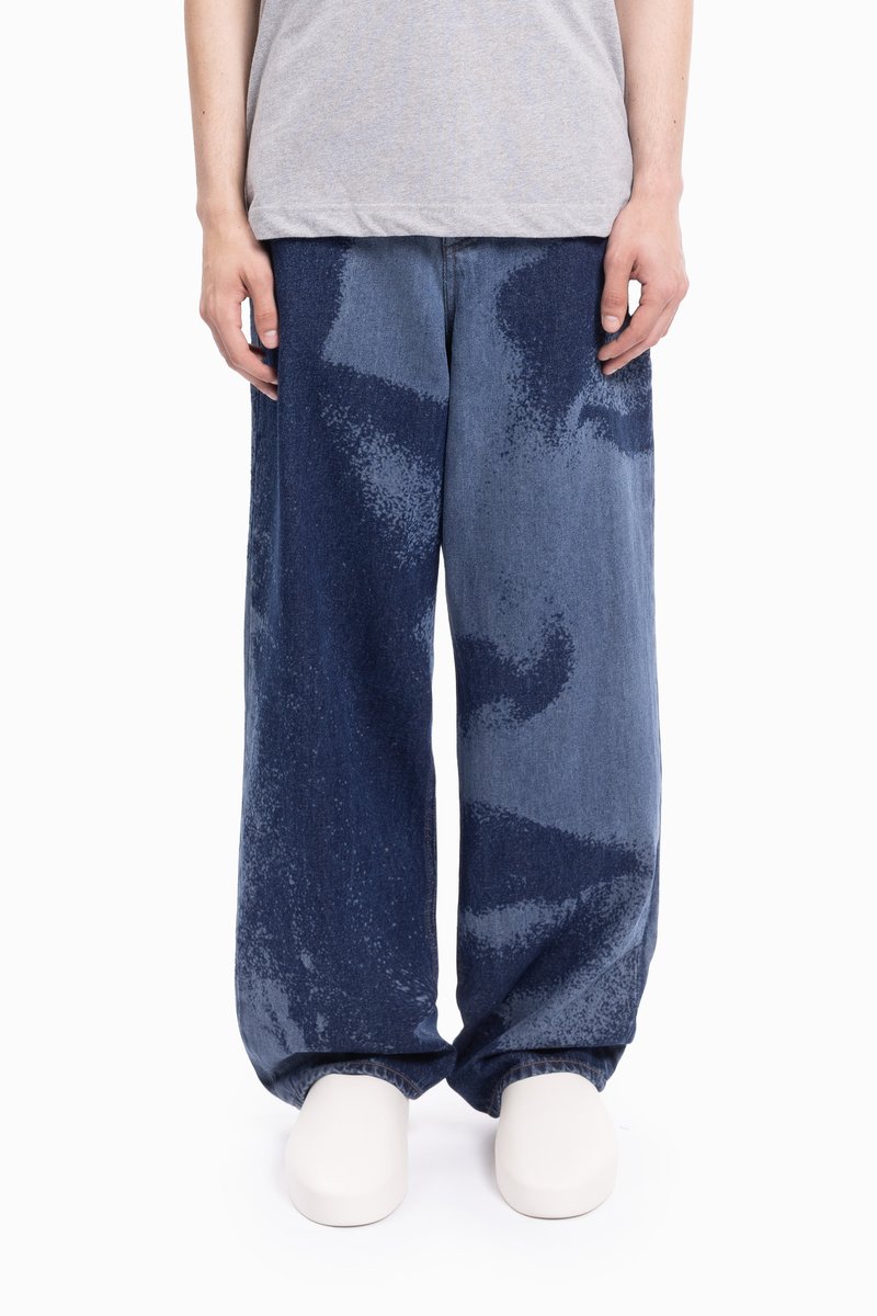 Široke jeans hlače prikazujejo gradient temno in svetlo modrih odtenkov, značilne po teksturiranem, pegastem vzorcu in sproščenem kroju.