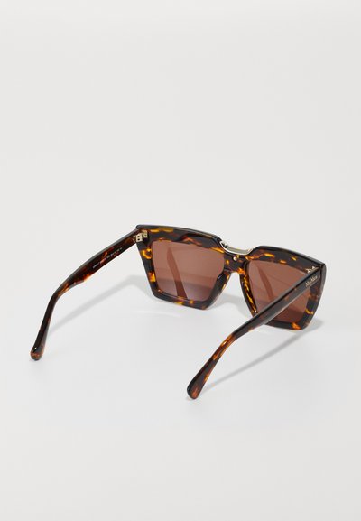 Lunettes de soleil angulaires avec une monture en écaille de tortue et des verres teintés marron. Comprend des accents en métal et une marque gravée sur la branche.
