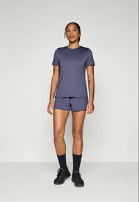 T-shirt e calções atléticos em cinza escuro, feitos de tecido que afasta a humidade. O design apresenta um corte relaxado e mangas curtas.