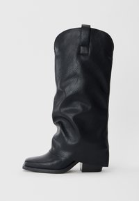 Stivali da cowboy in pelle nera con un design morbido, punta quadrata e tacco basso. Presenta un tassello sul retro per una facile calzata.
