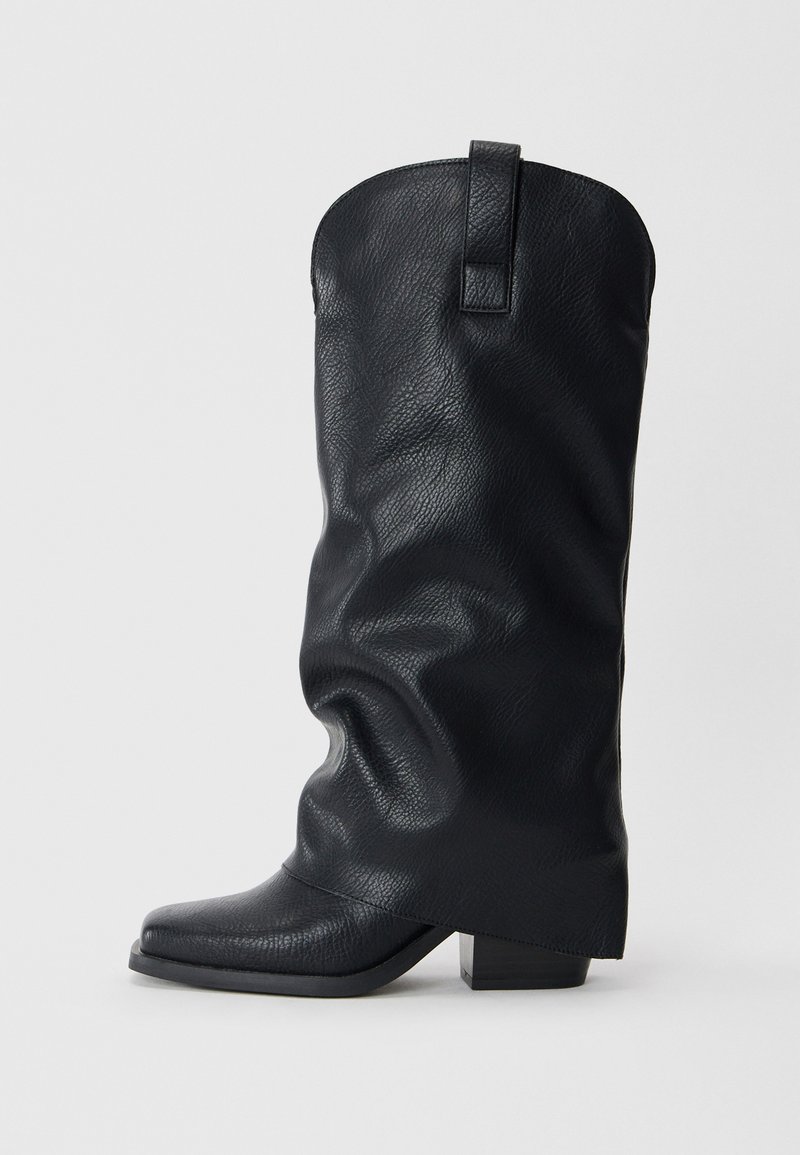 Stivali da cowboy in pelle nera con un design morbido, punta quadrata e tacco basso. Presenta un tassello sul retro per una facile calzata.