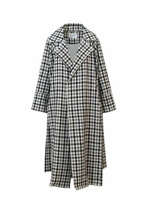 Lang kåpe i svart-hvitt rutemønster med brede slag og en enkelspent front, vist mot en hvit bakgrunn.