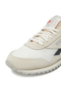 Beige sneaker with a mix of suede and fabric, featuring white laces, a grey outsole, and a red star logo on the tongue.