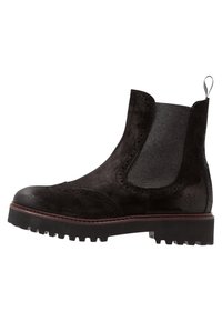 Stivaletto Chelsea in suede nero con pannello in pelle, dettagli brogue, suola robusta con trazione e un pratico tassello sul retro per facilitarne l'indossamento.