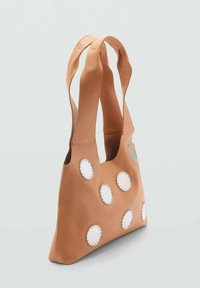 Borsa a tracolla in pelle tan con doppie maniglie larghe, caratterizzata da accenti bianchi rotondi cuciti sulla superficie. Texture liscia, design minimalista.