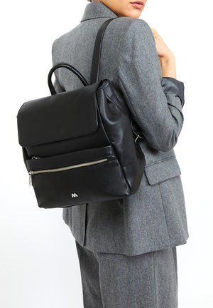 Mochila de cuero negro con un bolsillo frontal con cremallera y una solapa plegable. Cuenta con una asa superior y correas ajustables. Acabado texturizado.
