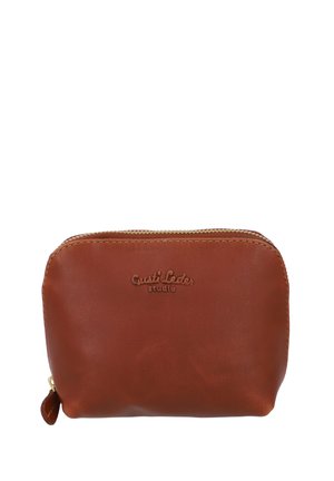 Borsetta in pelle marrone con forma arrotondata, zip dorata e logo in rilievo "Gusti Leder studio" sulla parte frontale. Texture liscia e design minimal.