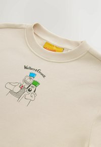 Cremefarbener Sweatshirt mit geripptem Rundhalsausschnitt und bedrucktem Motiv von zwei Cartoonfiguren, eine mit blauer Krone und die andere mit grüner.