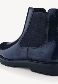 Bottine en cuir bleu marine avec panneau latéral élastique, corps texturé et semelle robuste. Finition brillante et coutures renforcées.