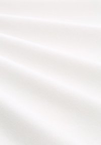 Weißer Stoff mit einer glatten, leicht strukturierten Oberfläche, die weiche Falten und Falten in einem leichten Material zeigt.