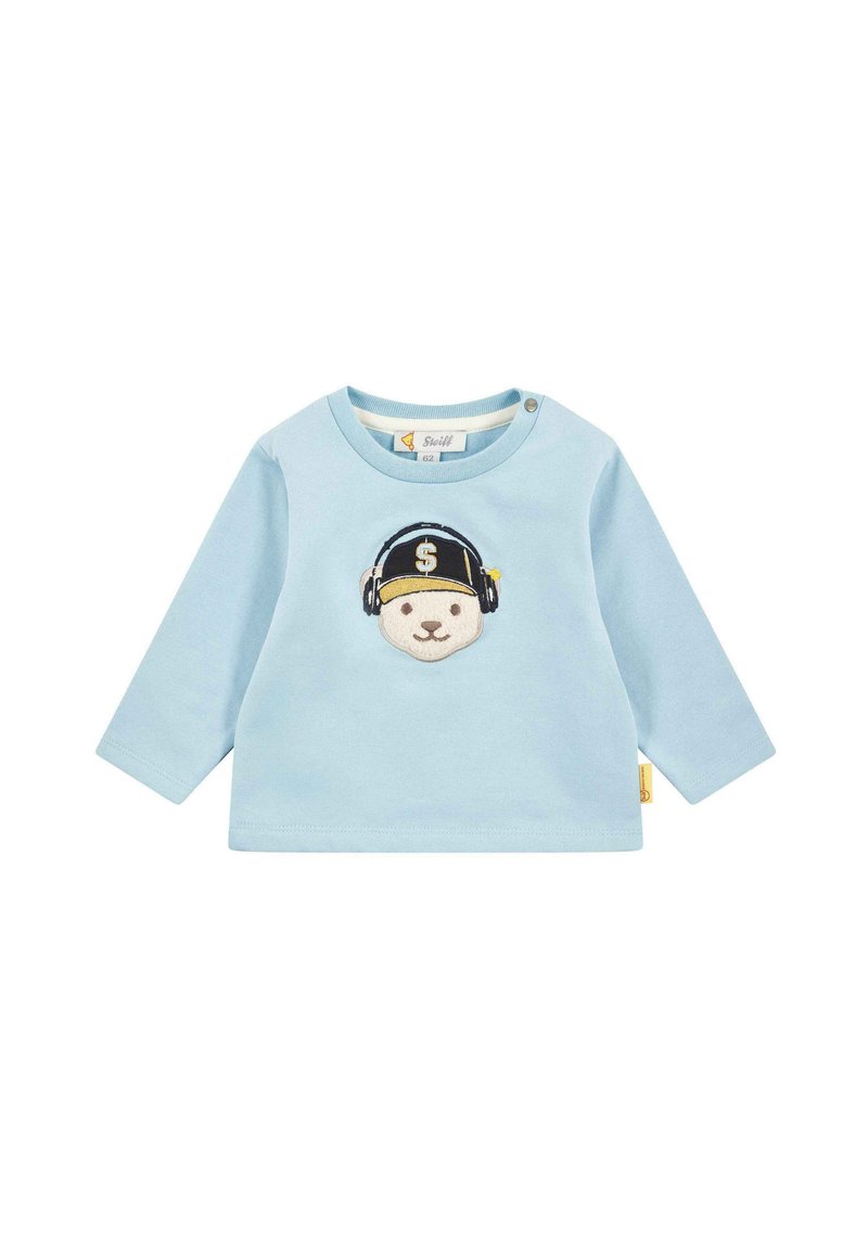 Chemise à manches longues bleu clair avec un col rond, ornée d'un ours brodé portant des écouteurs et une casquette avec un signe dollar.