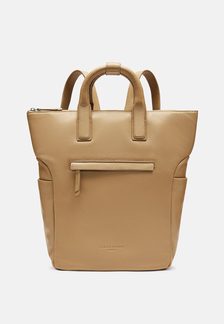 Beige Leder-Rucksack mit zwei Griffen, Reißverschluss, Front- und Seitentaschen, glatter Textur und minimalistischen Design.