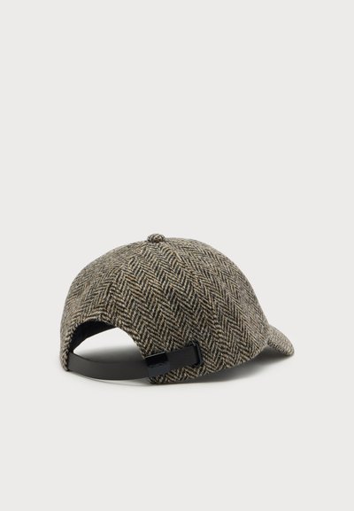 Casquette de baseball marron et beige à motif chevrons avec sangle noire réglable, vue de dos sur un fond clair uni.
