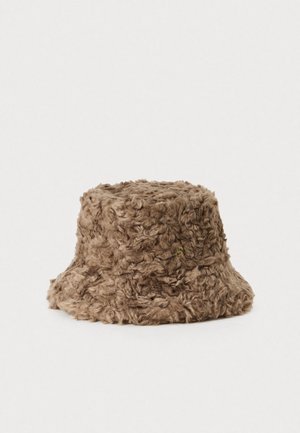 Cappello a secchiello in finto pelliccia riccia marrone con una piccola spilla dorata sul lato, esposto su uno sfondo bianco.