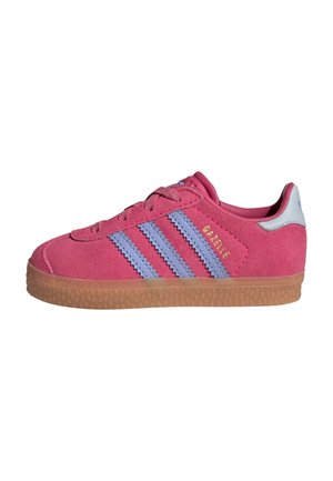 Różowy zamszowy sneaker z jasnofioletowymi paskami, gumową podeszwą i złotym napisem „GAZELLE” z boku, widziany od zewnętrznej strony.