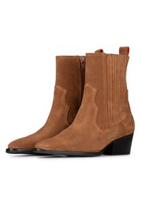 Botas de ante marrón hasta el tobillo con puntera puntiaguda, costuras decorativas, cremallera lateral y un tacón cuadrado de 5 centímetros. Presenta estrías verticales y acentos rojos.