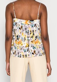 Flerfärgad ärmlös topp med ett blommönster i gult, teal och grått; veckad textur med tunna axelband.