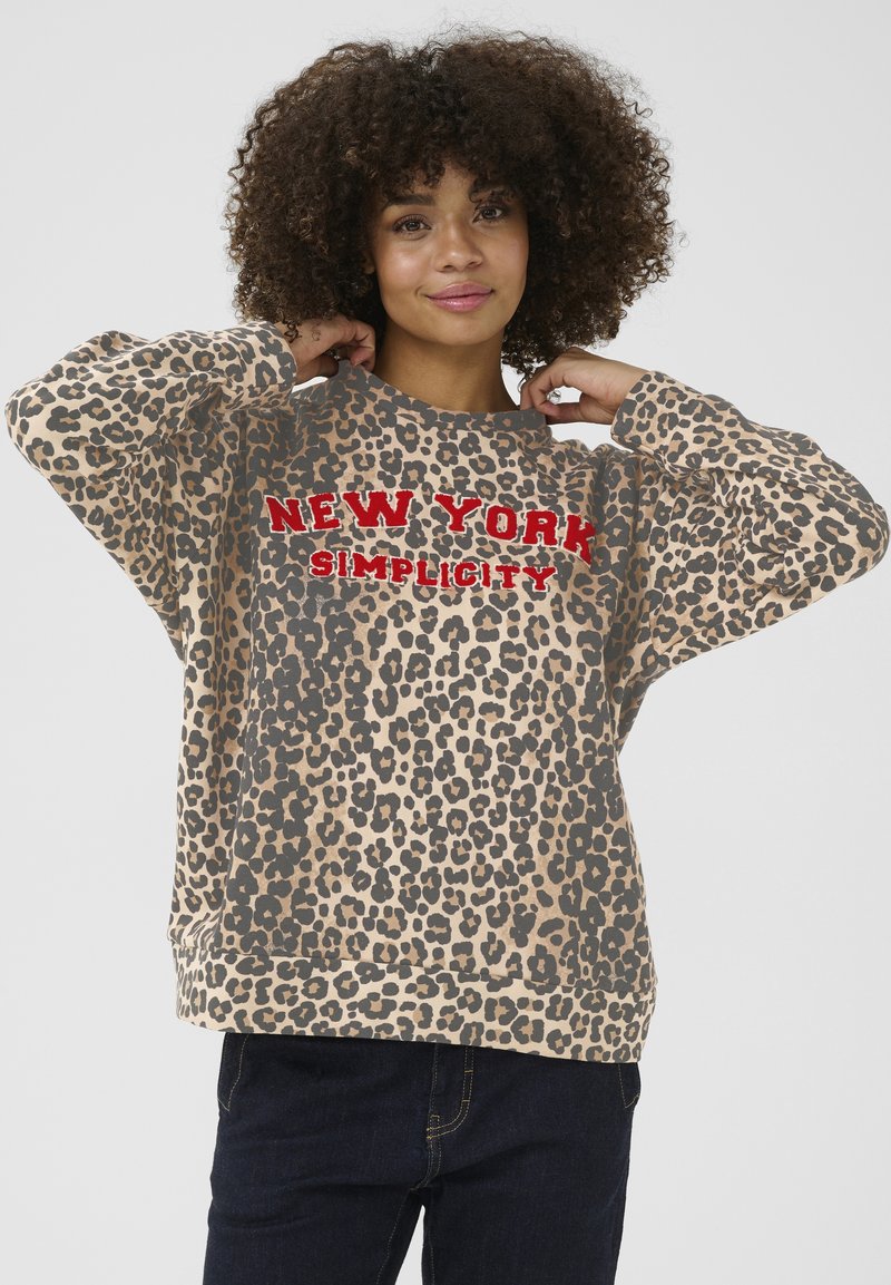 Mikina s leopardím vzorom v béžovej farbe, s červeným textom "NEW YORK SIMPLICITY". Voľný strih s okrúhlym výstrihom a dlhými rukávmi.