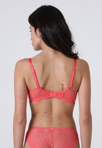 Bralette in pizzo corallo con spalline regolabili e chiusura con gancetto. Il motivo floreale e i bordi scallop rendono il design ancora più raffinato. Tessuto morbido.
