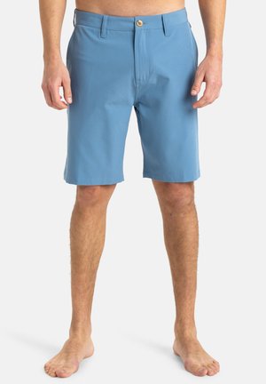 Shorts bleu clair fabriqués dans un tissu à texture lisse. Dotés d'une fermeture à bouton, de passants de ceinture et d'un design à coupe droite.