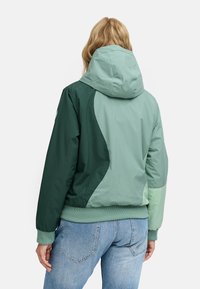 Green and mint hooded jacket with color-block design, ribbed cuffs, and hem. Smooth texture with a relaxed fit and adjustable hood.