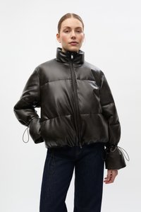 Geacă matlasată neagră din material sintetic mat, cu guler înalt, închidere cu fermoar și șnururi ajustabile la manșete și talie.