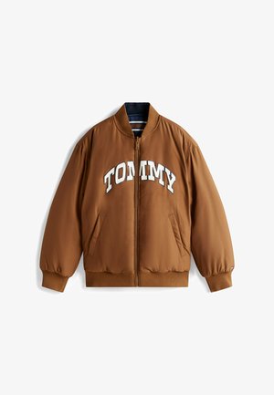 Brązowa kurtka bombowiec z zamkiem z przodu, elastycznymi mankietami i dołem. Posiada napis "TOMMY" w białych literach na wysokości klatki piersiowej. Wykonana z gładkiego materiału.