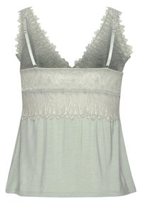 Light green camisole with a lace bodice, scalloped straps, and a flowy lower section. Soft fabric with intricate leaf patterns on the top.