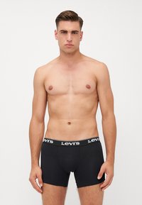 Fekete pamut boxer alsónadrág logózott gumírozott derékrésszel. A designtesthezálló fazonú és sima tapintású.