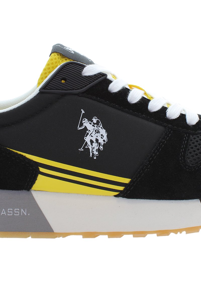 Czarne sneakersy z żółtymi akcentami i białymi sznurowadłami. Zawierają materiał zamszowy i siateczkowy, gumową podeszwę oraz grafikę polo gracza na boku.