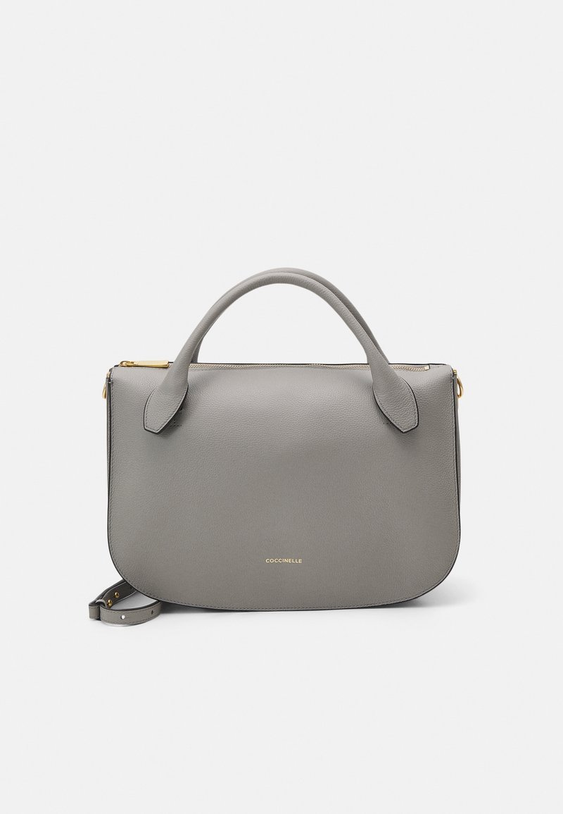 Borsa a mano in pelle grigia con una texture liscia, manici arrotondati, dettagli in hardware dorato e chiusura con zip. Design minimalista con dettaglio del logo.