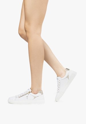 Zapatillas blancas con un diseño de malla texturizada, acentos plateados en el talón y un detalle de cremallera dorada; cierre con cordones y suela plana.