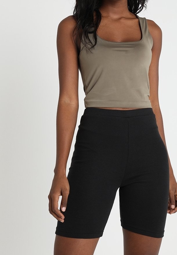 Olivengrön kort topp med fyrkantig halsringning, kombinerad med högmidjade svarta shorts. Slätt tyg med en åtsittande design.