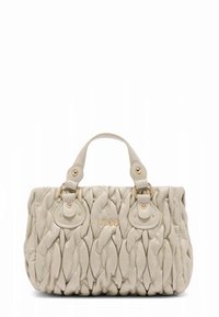 Sac à main crème avec un design matelassé, ferrures dorées, double poignée et un logo détaillé à l'avant. Matière douce et texturée.