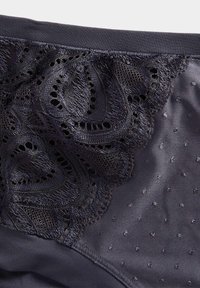 Mørkeblå undertøj med en blondepanel med blomsterprint, glat stof med små forhøjede prikker og en blød elastisk talje.