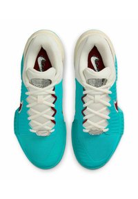 Zapatillas deportivas turquesas con empeine de malla blanca, acentos rojos y herrajes plateados. Suela de goma texturizada notable y patrón de cordones distintivo.