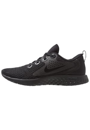 Chaussure de course Nike noire avec tige en mesh, lacets à l'avant, semelle rembourrée et languette au talon, vue de côté sur fond blanc.