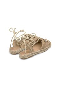 Beżowe espadryle z plecionki z góry z tekstyliów, design na sznurowanie oraz plecionka z juty wzdłuż podeszwy. Zawierają dekoracyjne akcenty.