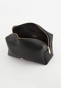 Trousse de maquillage noire texturée avec une fermeture éclair et des accessoires dorés, présentant un intérieur spacieux et une étiquette de marque à l'intérieur.
