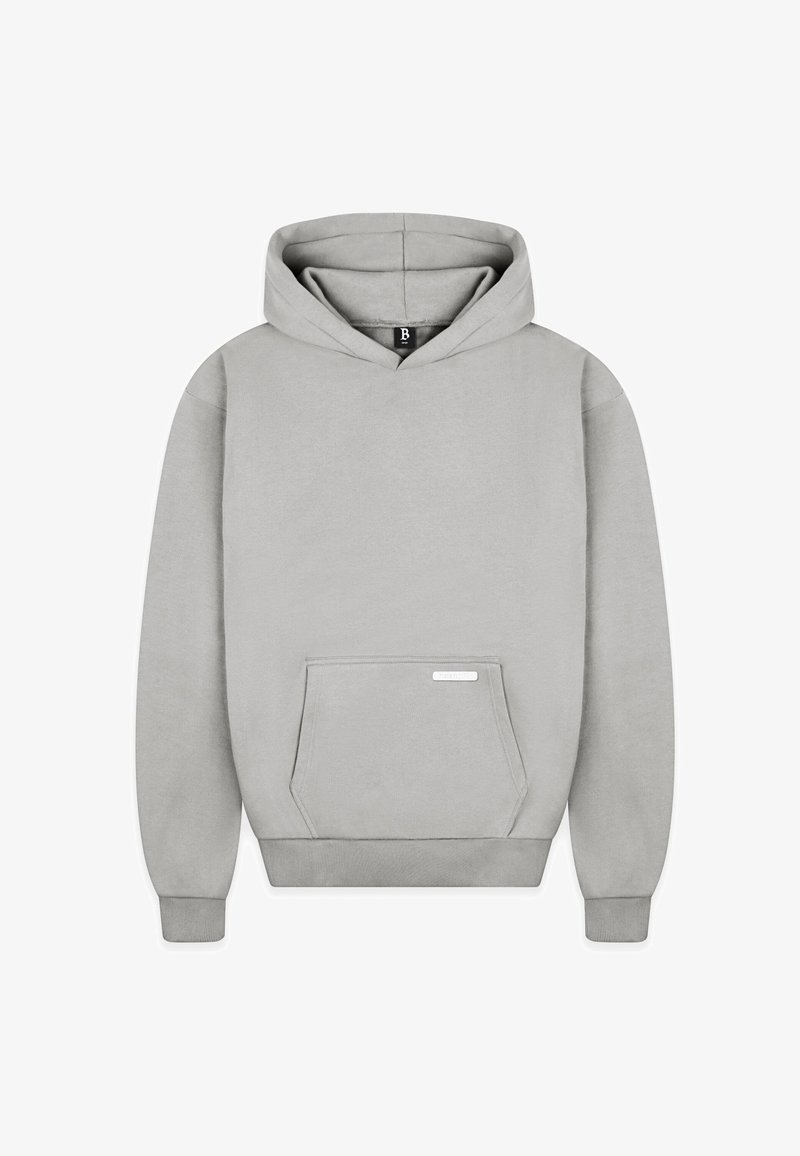 Sweat à capuche gris clair en tissu doux, avec une poche kangourou à l'avant et des poignets et un ourlet côtelés. Présente une petite étiquette sur la poche.