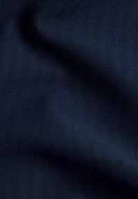 Tmavomodrý textil s jemnou textúrou a subtilným tkaním. Hladký povrch s jemným leskom a príjemným padaním. Žiadne viditeľné vzory alebo ozdoby.